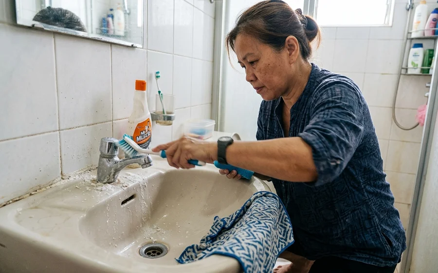 Scrubbing limescale from a bathroom tap and grout lines